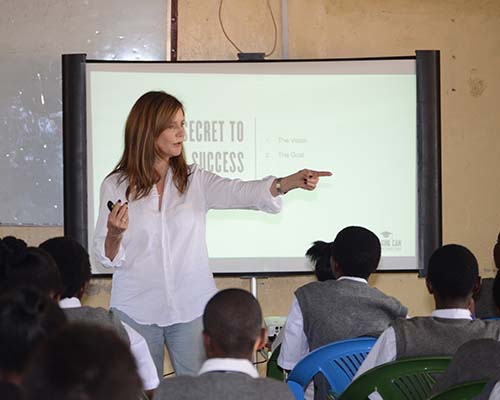 Lotte gesturing to student while presenting in front of slideshow